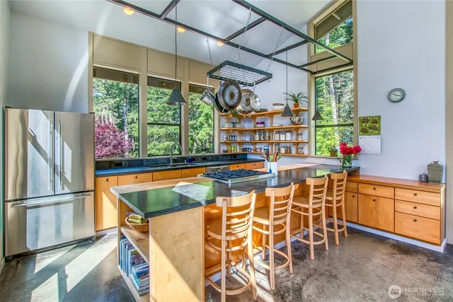 a kitchen with stainless steel appliances granite countertop a sink and a refrigerator