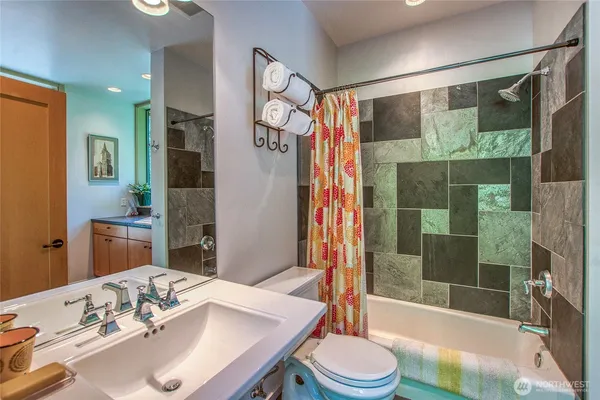 a bathroom with a granite countertop sink toilet and shower