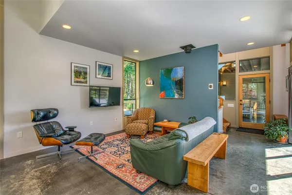 a living room with furniture a flat screen tv and a window