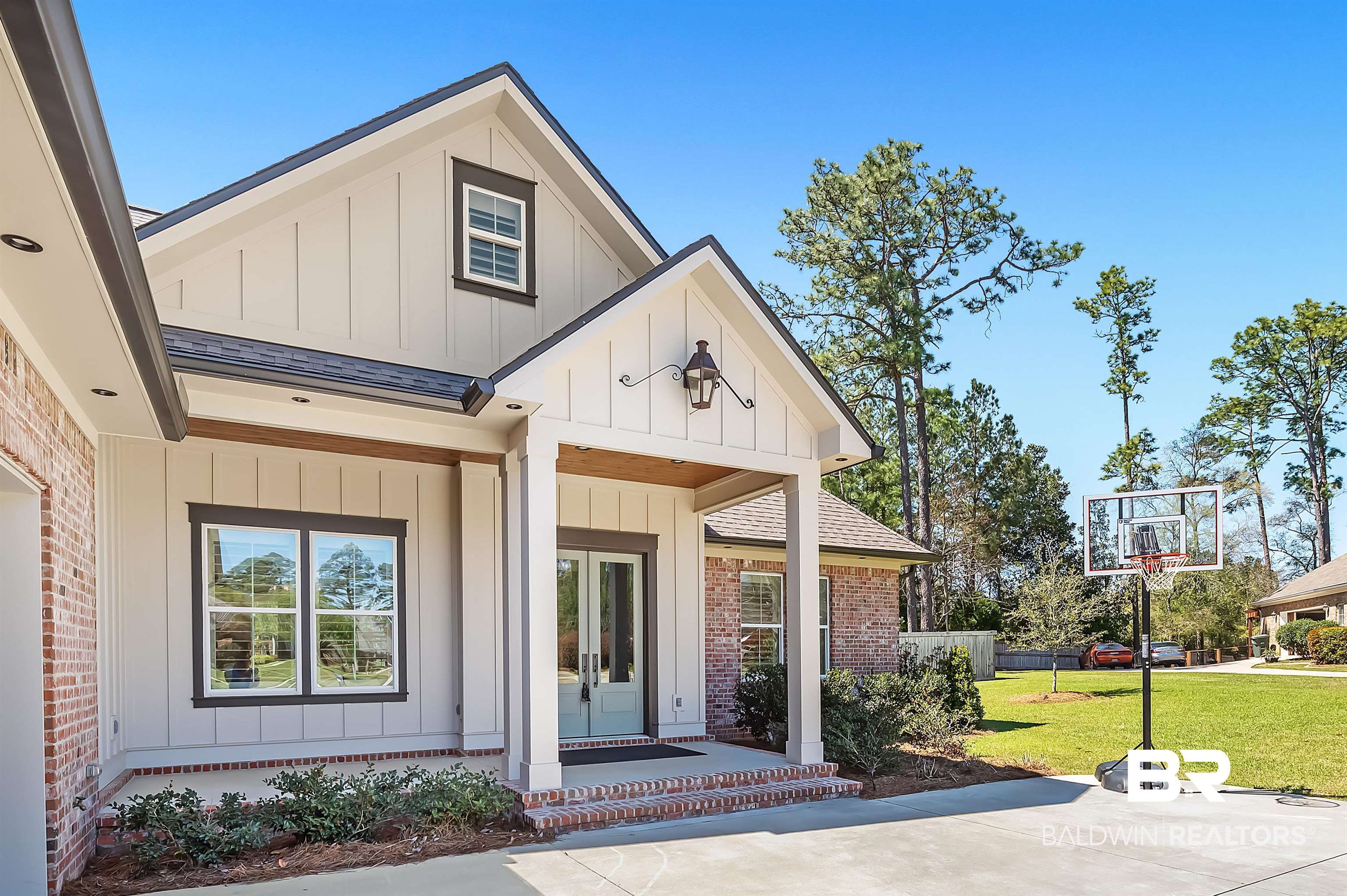 27888 Oakachoy Loop Daphne, AL 36526 - Photo 58 of 65 Doorway to property featuring brick siding, board and batten siding, roof with shingles, a lawn, and french doors