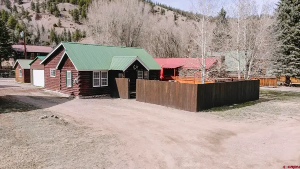 a view of a house with a wooden fence