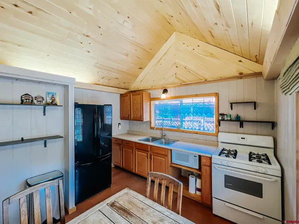 a kitchen with stainless steel appliances a stove a refrigerator and a window