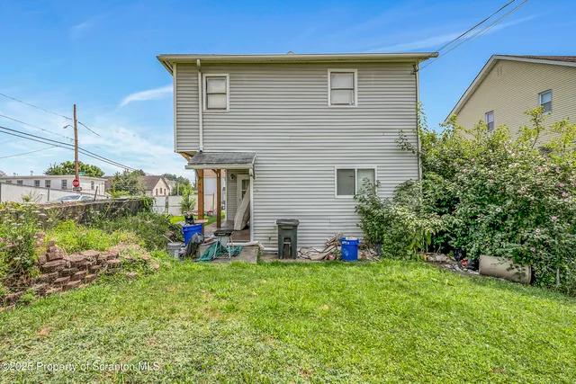 a view of a chair and table in backyard of the house