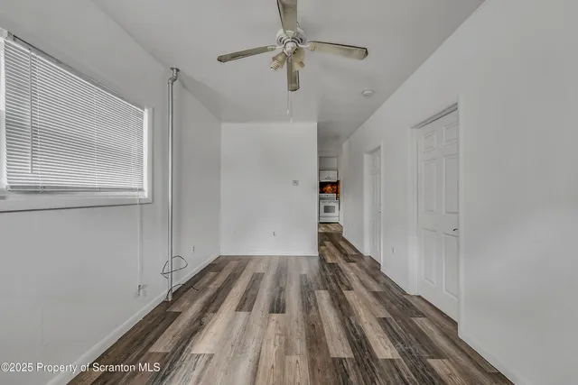 a view of a room with wooden floor closet and windows