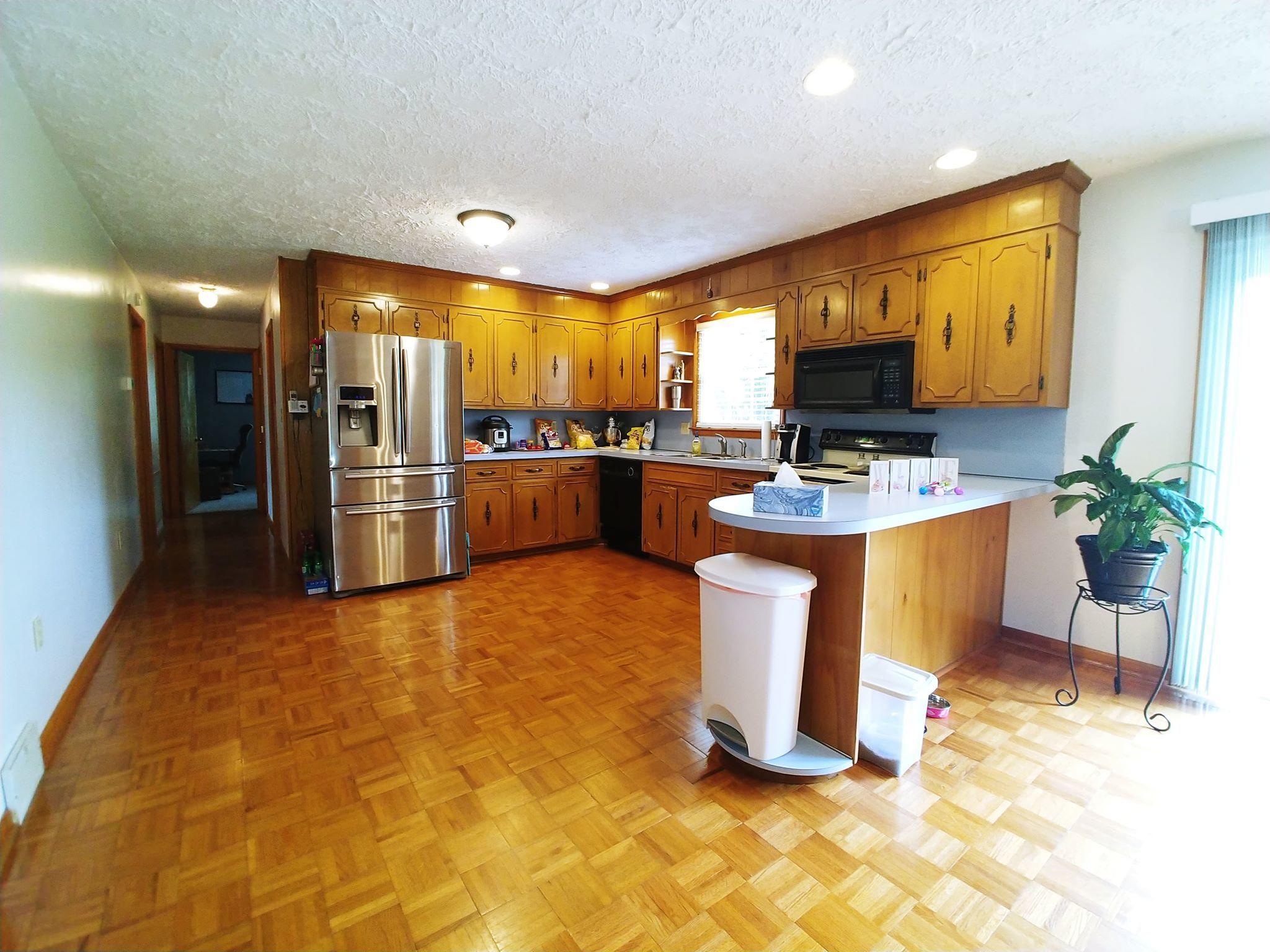 461 Old Forge Road Callaway, VA 24067 - Photo 8 of 29 a kitchen with stainless steel appliances kitchen island granite countertop a refrigerator a stove a sink a dining table and chairs with wooden floor