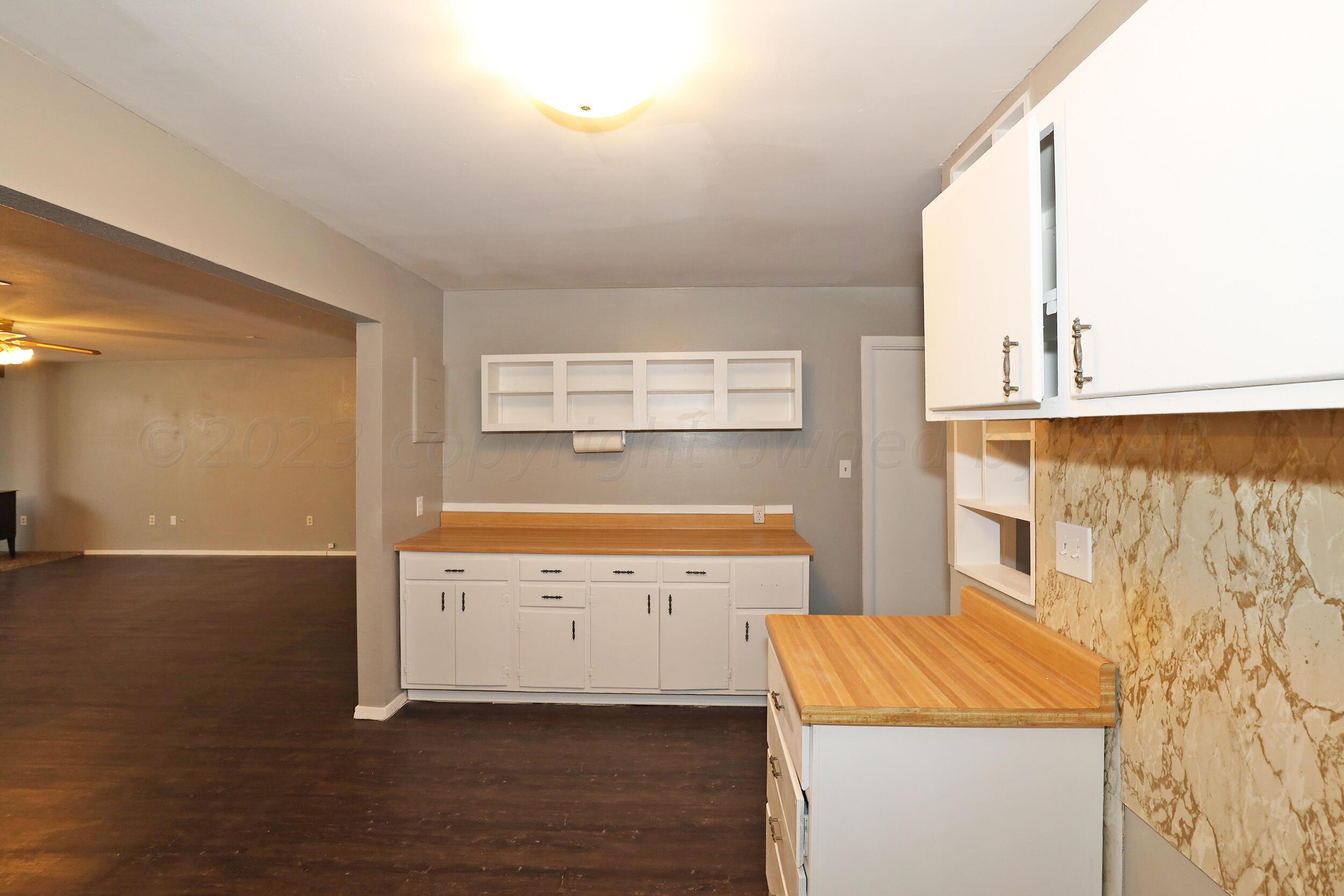 3820 Beaver Drive Amarillo, TX 79107 - Photo 17 of 25 a view of a kitchen with wooden floor and cabinets