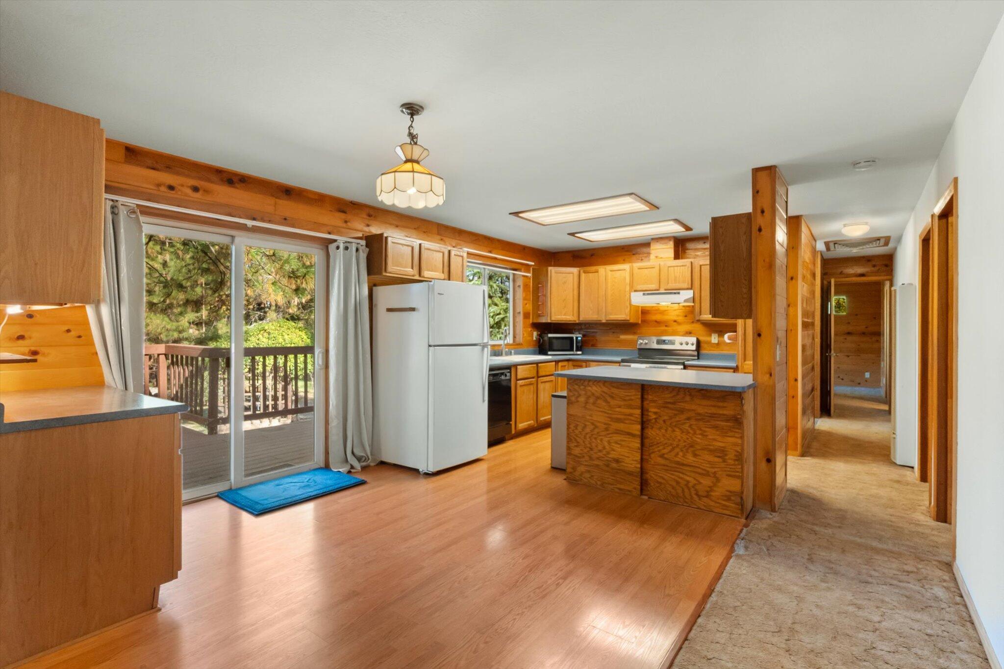 28449 Whippoorwill Circle Shingletown, CA 96088 - Photo 9 of 47 a kitchen with refrigerator a island and wooden cabinets