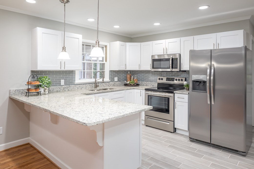 8913 Hunting Trail Raleigh, NC 27613 - Photo 6 of 19 The open kitchen offers NEW cabinets, GRANITE counters, TILE backsplash, SS appliances, recessed lighting, and upgraded tile floors. Large ISLAND with room for bar stools for quick snack. Kitchen
