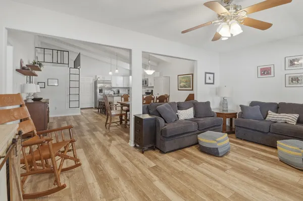 a living room with furniture a dining table and chairs with wooden floor