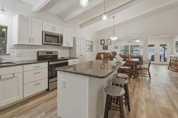 a kitchen with stainless steel appliances granite countertop a sink a stove and cabinets