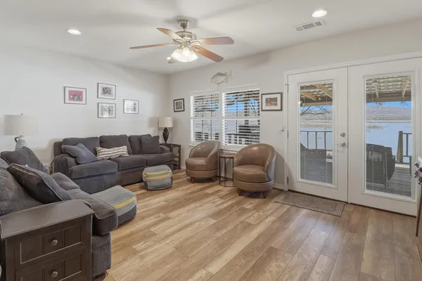 a living room with furniture ceiling fan and a wooden floor