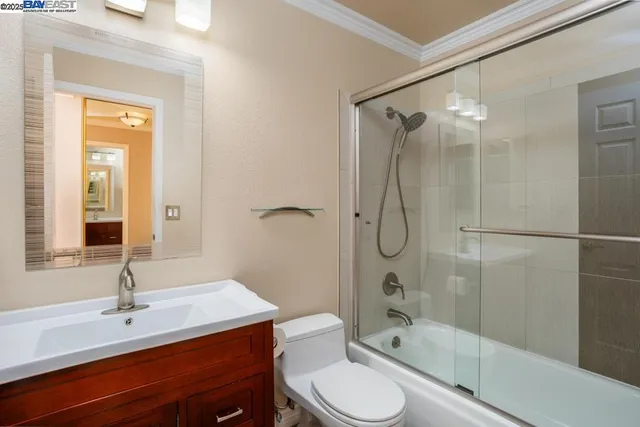 a bathroom with a shower sink vanity mirror and toilet