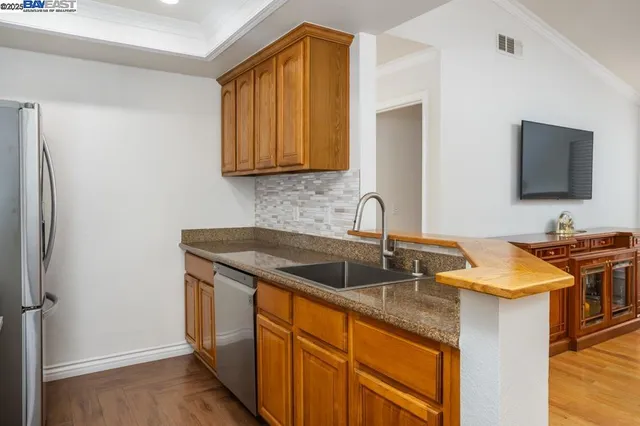 a kitchen with stainless steel appliances granite countertop a sink stove and refrigerator