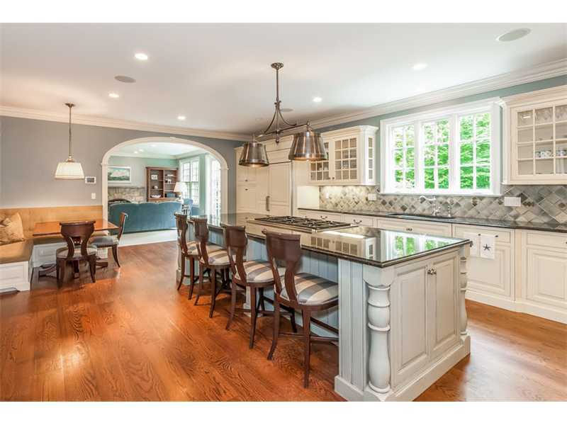46 Stony Brook Road Darien, CT 06820 - Photo 7 of 24 a open kitchen with stainless steel appliances granite countertop a stove top oven a dining table and chairs with wooden floor