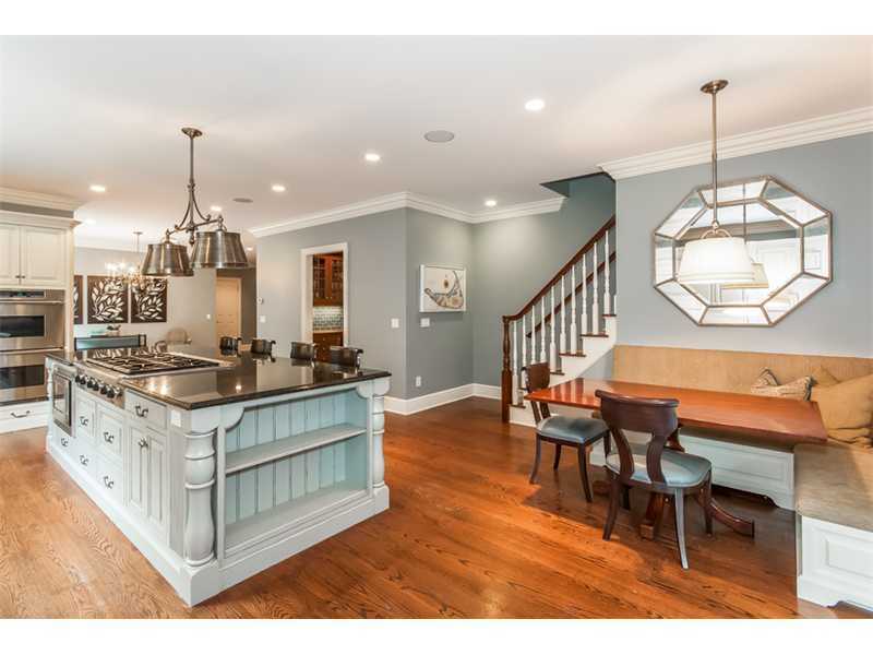 46 Stony Brook Road Darien, CT 06820 - Photo 8 of 24 a kitchen with stainless steel appliances kitchen island granite countertop a table chairs in it and wooden floors