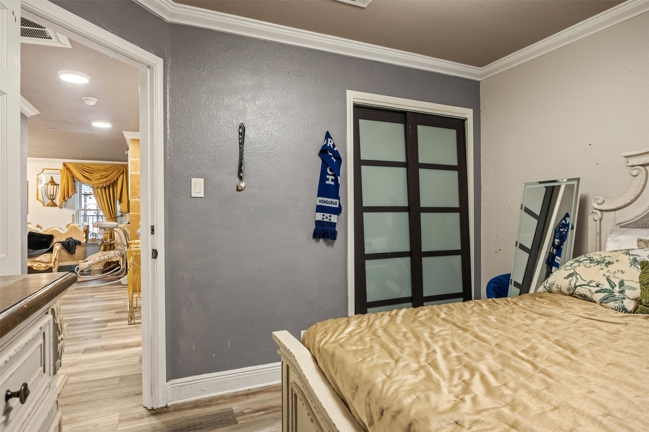 14409 Sandifer Street Austin, TX 78725 - Photo 18 of 31 Bedroom featuring ornamental molding, light wood finished floors, and a textured wall