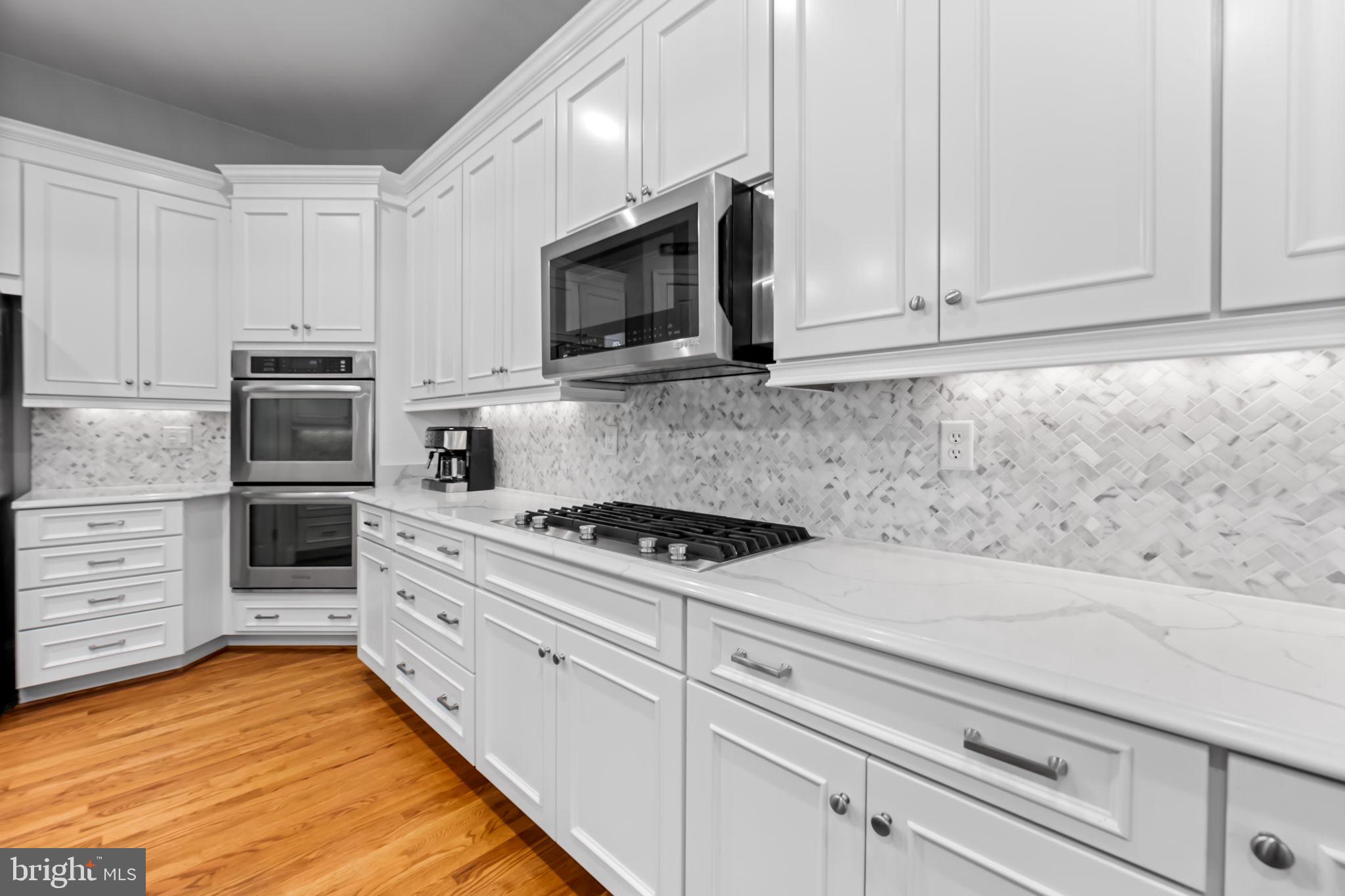 6509 Abbey View Way, Unit 22 Baltimore, MD 21212 - Photo 16 of 54 a kitchen with white cabinets and stainless steel appliances