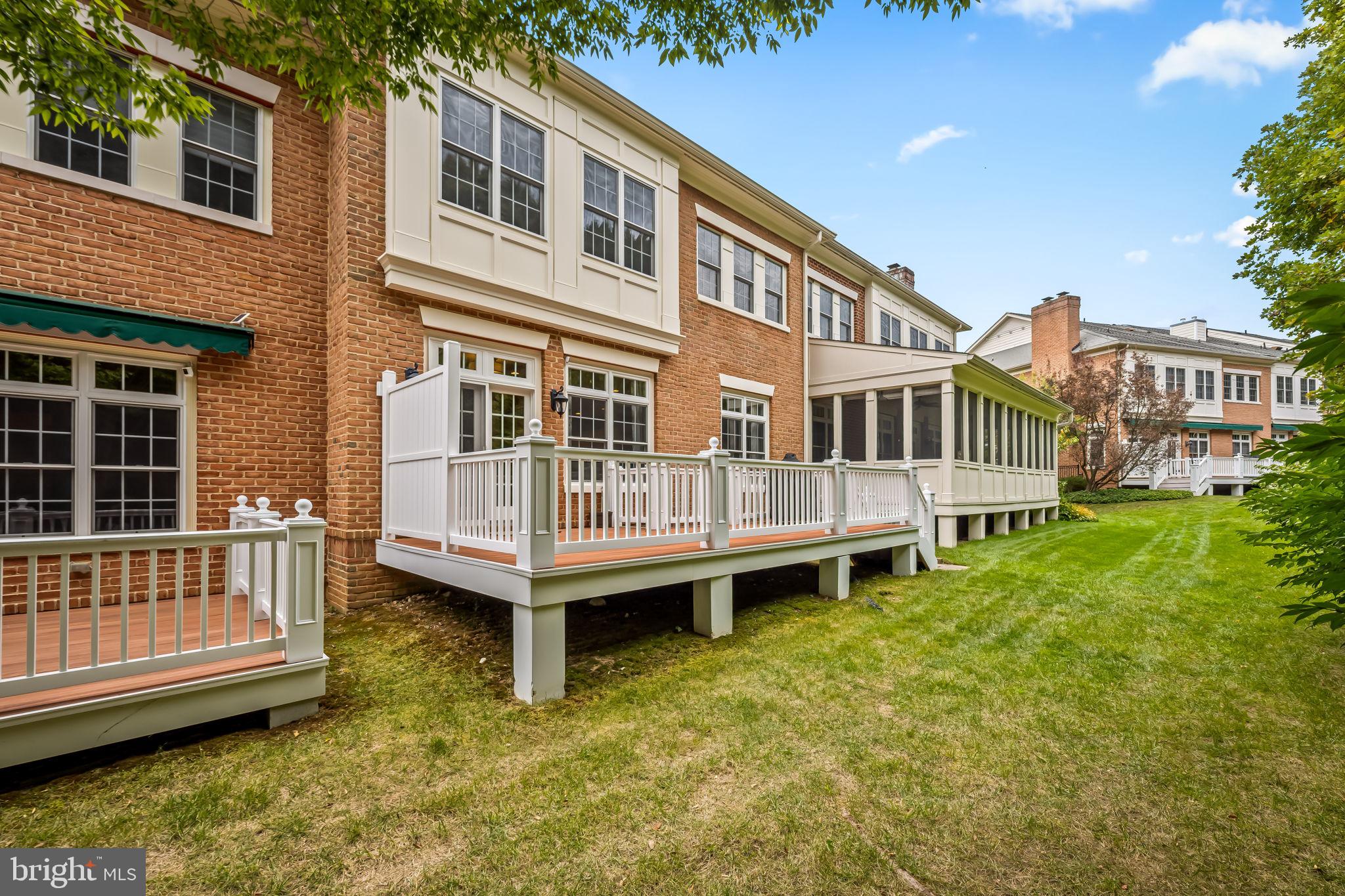 6509 Abbey View Way, Unit 22 Baltimore, MD 21212 - Photo 49 of 54 a view of a house with a wooden deck and a small yard