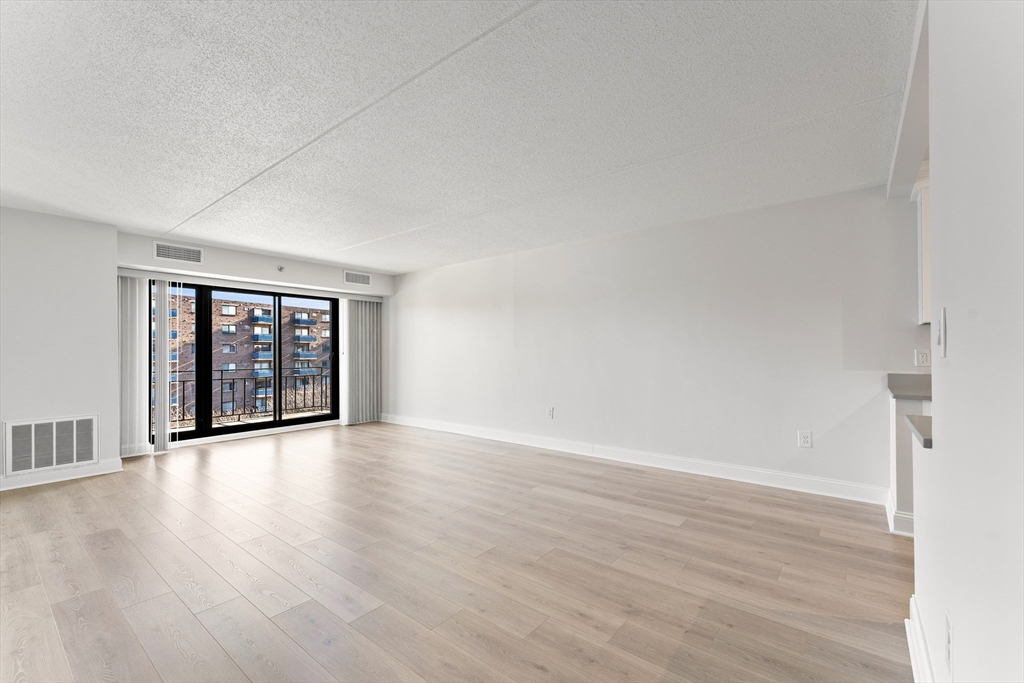 275 Main Street, Unit 205 Watertown, MA 02472 - Photo 11 of 42 a view of an empty room with wooden floor and a window