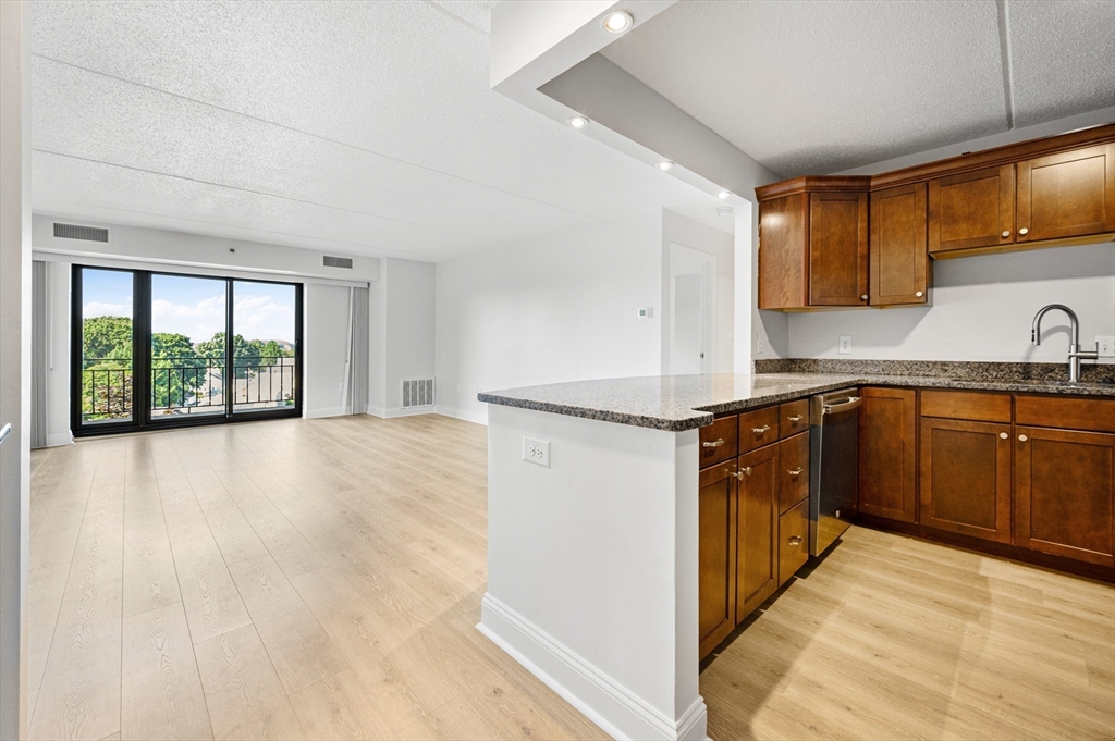 275 Main Street, Unit 205 Watertown, MA 02472 - Photo 2 of 42 a kitchen with a refrigerator sink and wooden cabinets