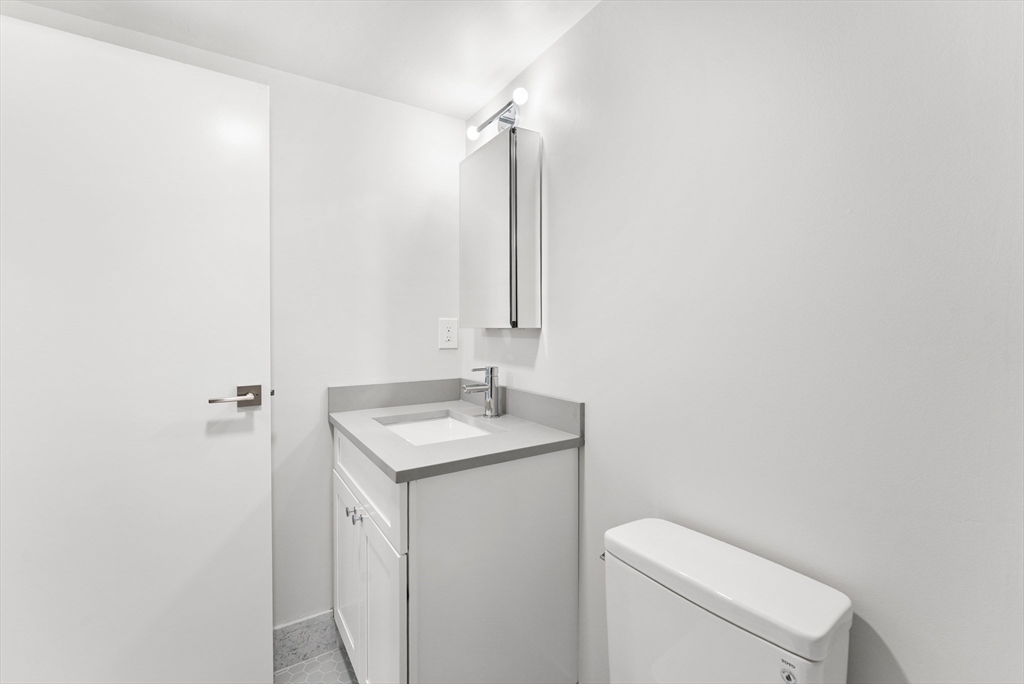 275 Main Street, Unit 205 Watertown, MA 02472 - Photo 25 of 42 a bathroom with a toilet sink and mirror