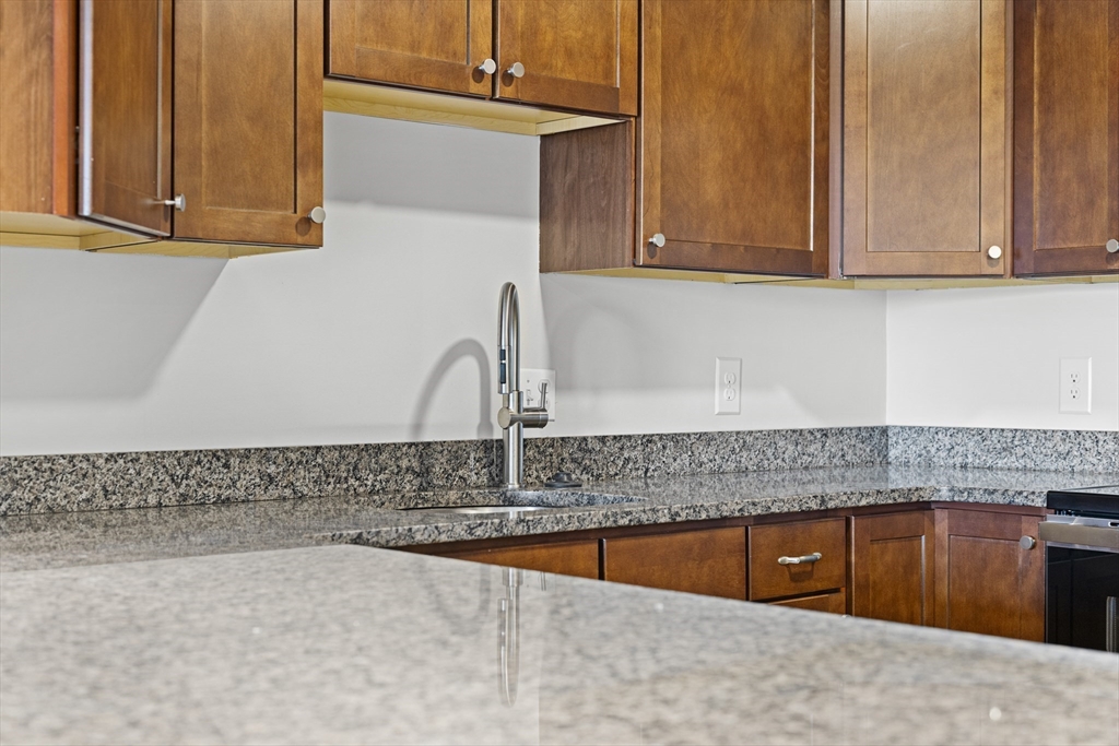 275 Main Street, Unit 205 Watertown, MA 02472 - Photo 4 of 42 a kitchen with granite countertop a sink and cabinets