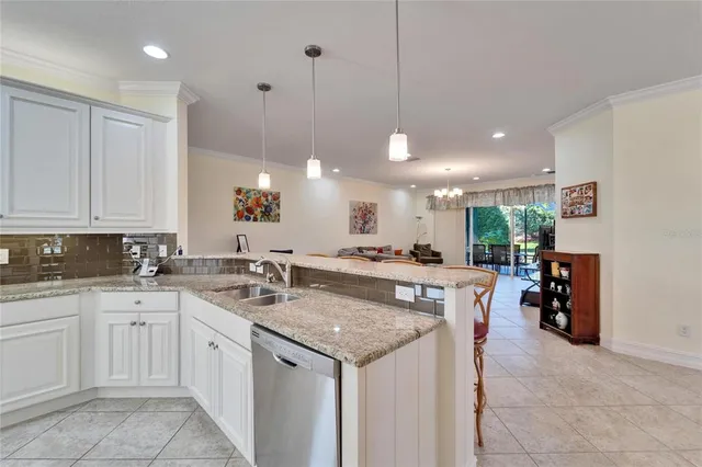 a kitchen with stainless steel appliances granite countertop white cabinets and refrigerator
