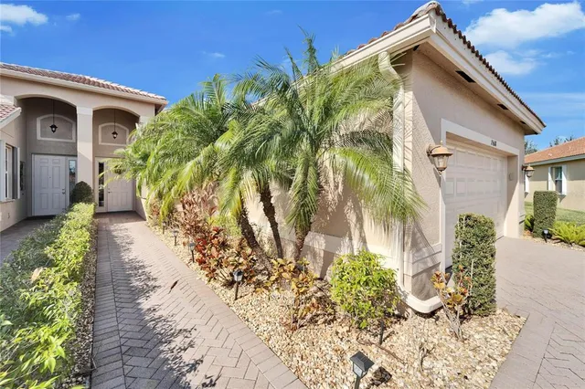 a front view of a house with a yard and potted plants