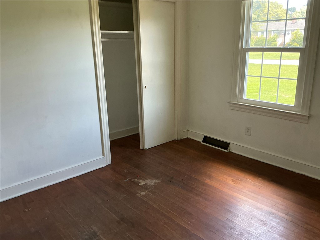 609 West Geer Street Honea Path, SC 29654 - Photo 12 of 18 Rich hardwood floors and a classic sash window define this versatile bedroom space.