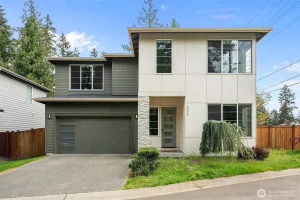 a front view of a house with a garden and garage