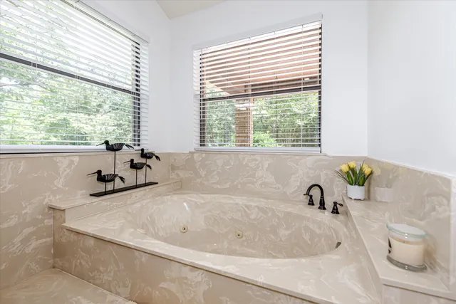 a white bath tub sitting in a bathroom next to a window