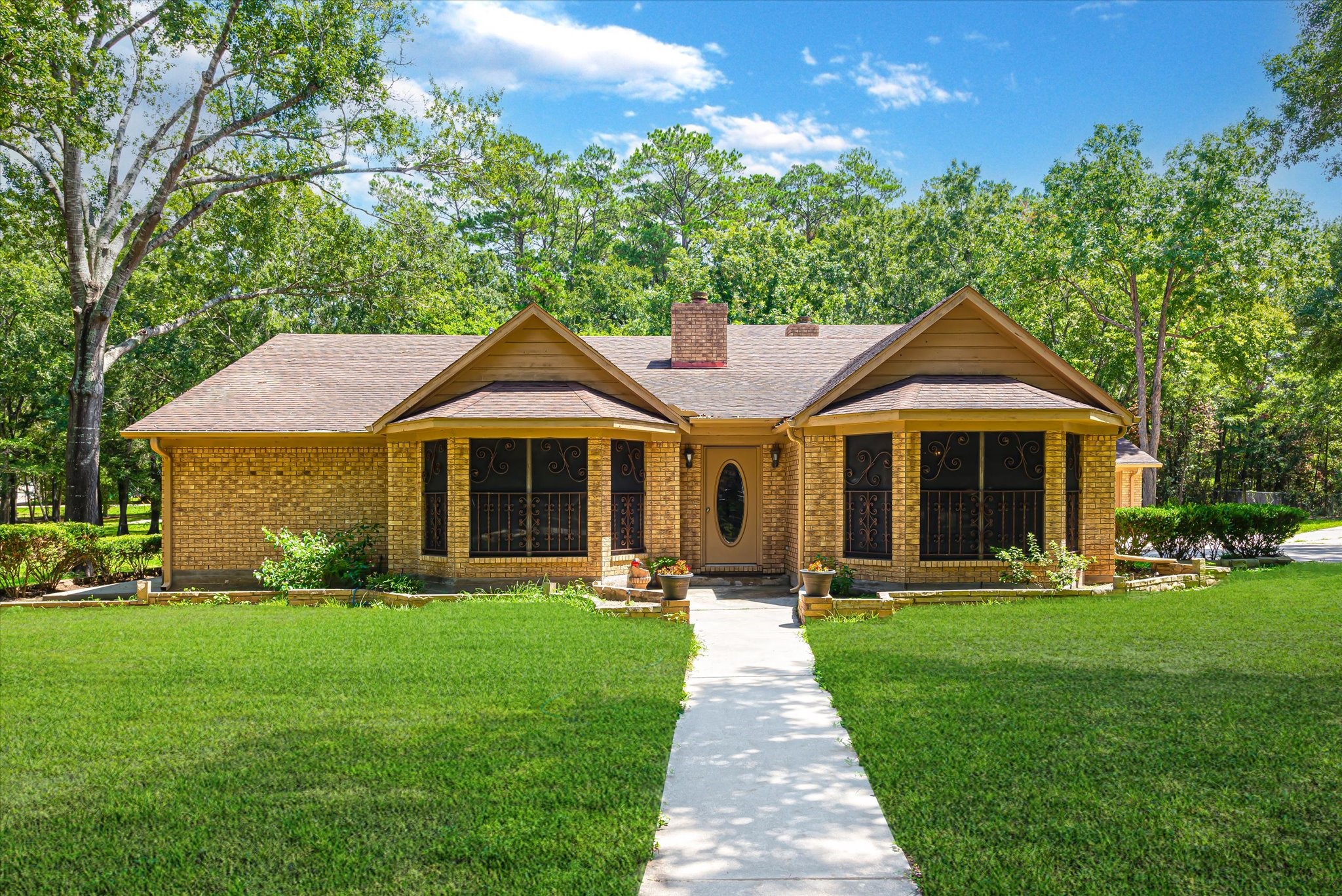 7715 Shadow Lane Conroe, TX 77304 - Photo 4 of 46 a front view of a house with a yard and trees