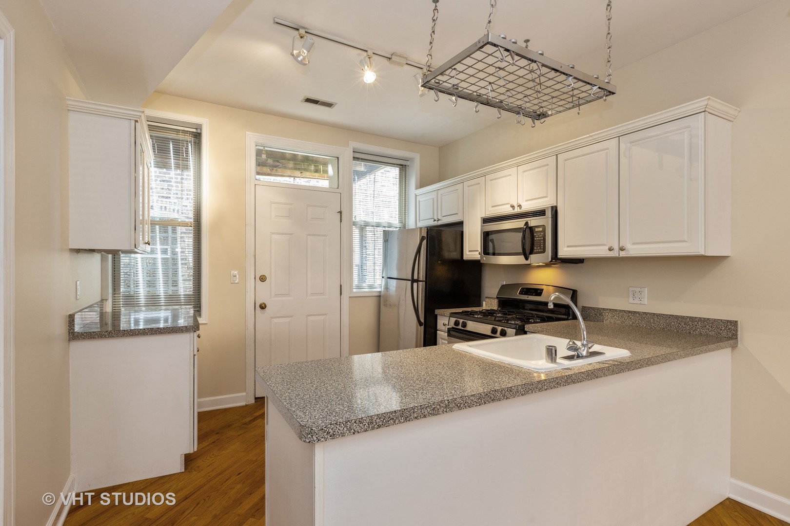 4632 North Racine Avenue, Unit 2 Chicago, IL 60640 - Photo 3 of 12 a kitchen with granite countertop a sink stainless steel appliances a counter top space and cabinets