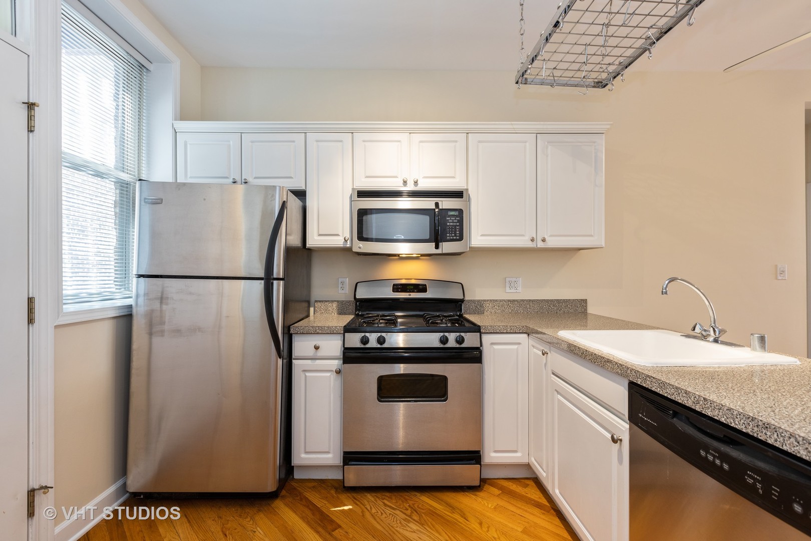4632 North Racine Avenue, Unit 2 Chicago, IL 60640 - Photo 5 of 12 a kitchen with a stove microwave and a refrigerator