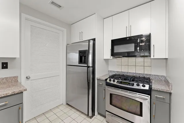 a kitchen with granite countertop a sink a counter space and cabinets