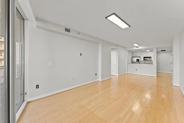 a view of a big room with wooden floor and a window