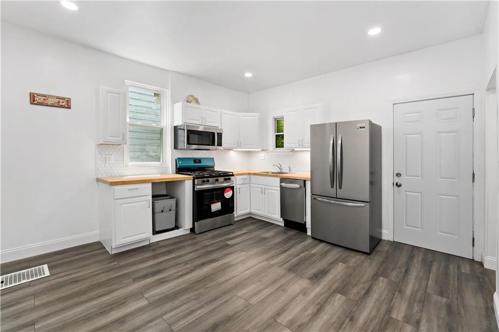 428 Card Avenue Wilmerding, PA 15148 - Photo 12 of 32 a kitchen with a refrigerator a stove top oven a sink dishwasher and wooden floor