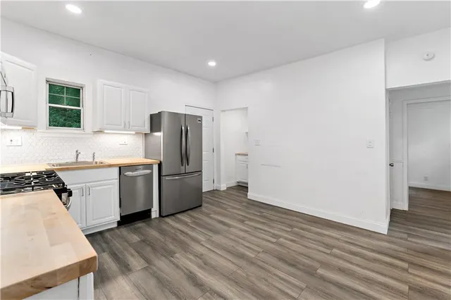 a kitchen with a refrigerator sink and cabinets