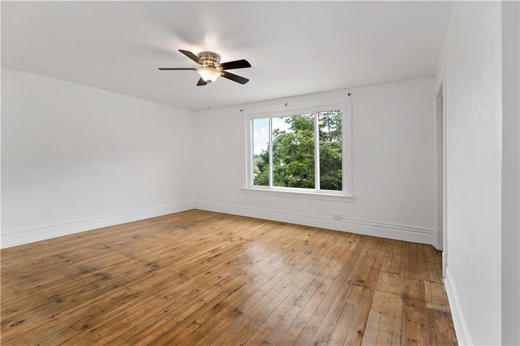 428 Card Avenue Wilmerding, PA 15148 - Photo 16 of 32 an empty room with wooden floor fan and windows