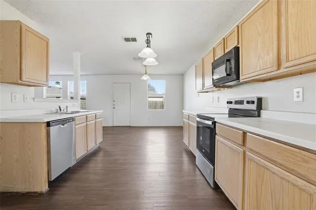 a kitchen with stainless steel appliances granite countertop a sink and cabinets