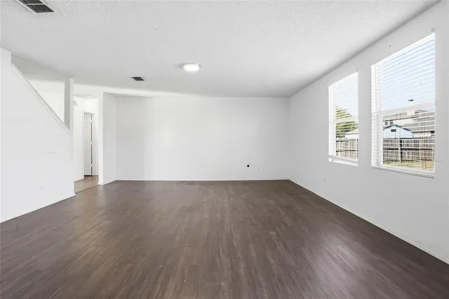 a view of a room with wooden floor and a window