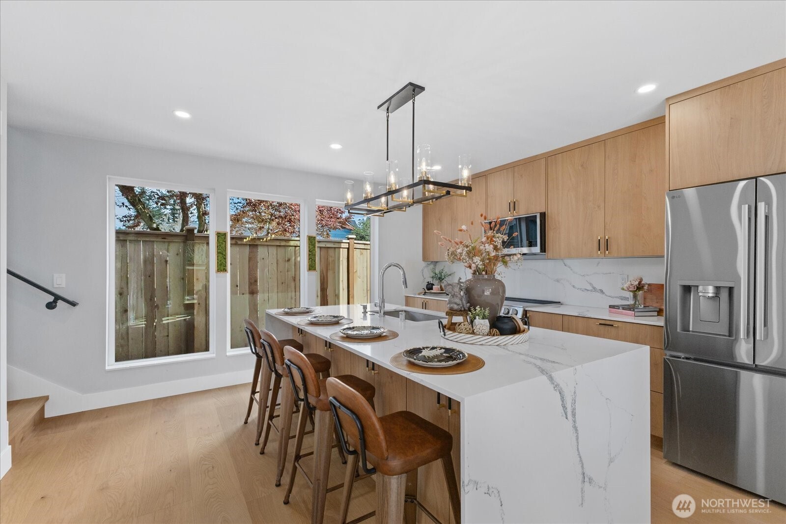 9537 Dayton Avenue North Seattle, WA 98103 - Photo 9 of 22 a kitchen with a table chairs refrigerator and microwave