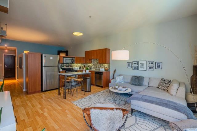 a living room with stainless steel appliances kitchen island furniture and a table