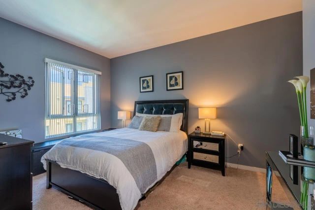 a bedroom with a bed table and a flat screen tv