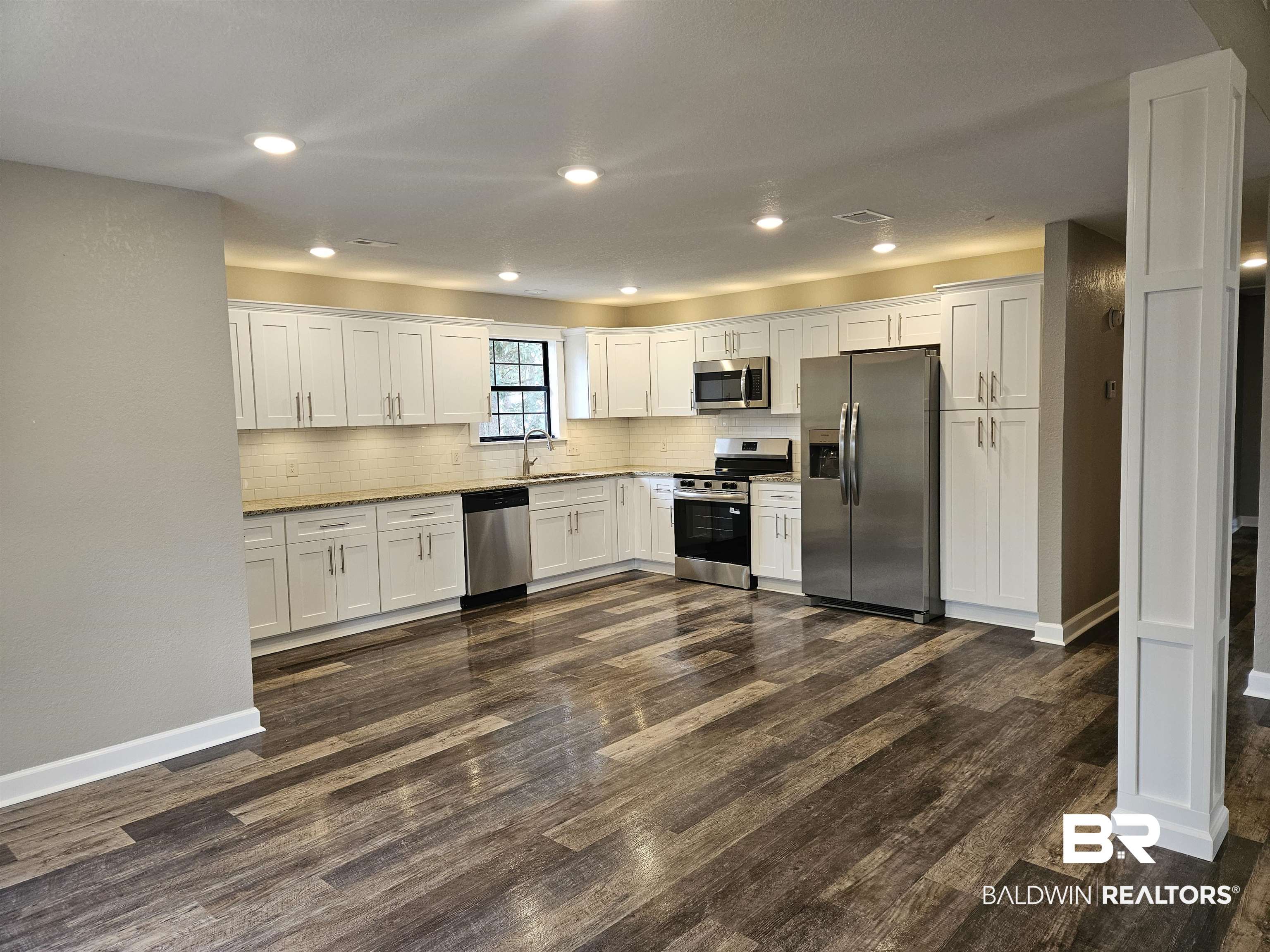 138 Wicker Way Daphne, AL 36526 - Photo 5 of 32 Kitchen featuring stainless steel appliances, white cabinetry, dark wood finished floors, recessed lighting, and backsplash