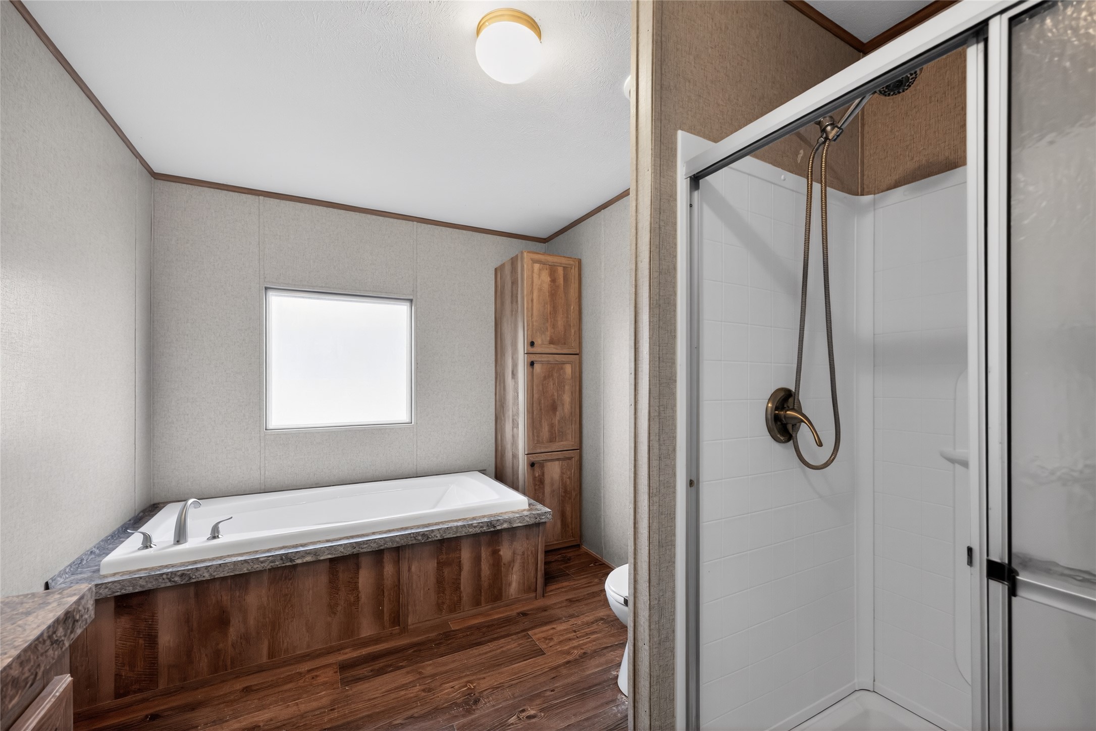 2674 Cotton Gin Road Kyle, TX 78640 - Photo 27 of 30 Full bathroom with a stall shower, dark wood-style floors, a bath, and ornamental molding