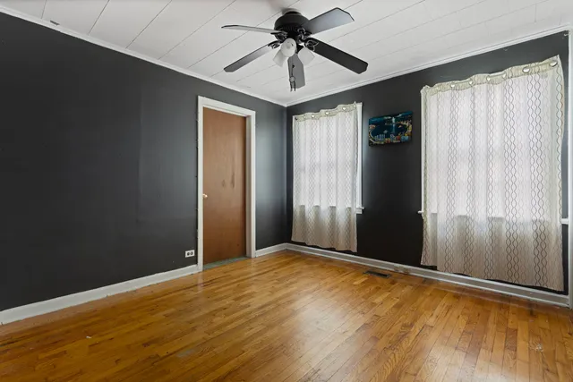 a view of a livingroom with a chandelier fan and wooden floor