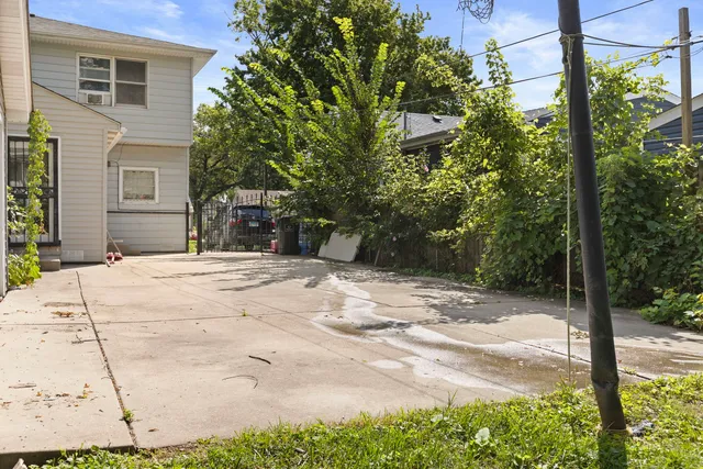 a view of a backyard with large trees and plants