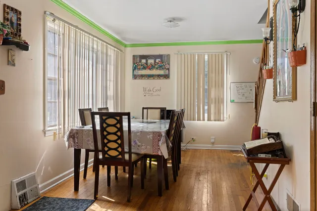 a view of a a dining room with furniture window and wooden floor