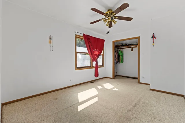an empty room with windows and ceiling fan view